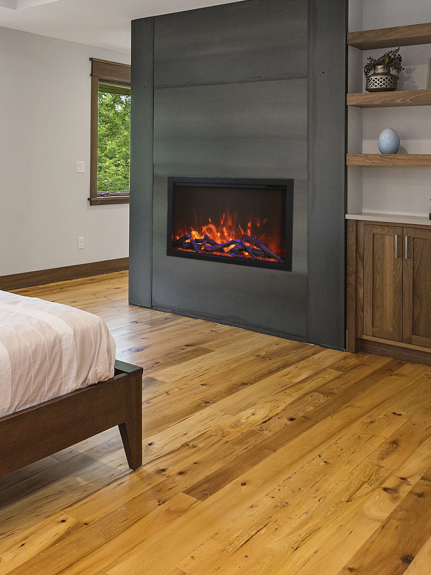 Cozy bedroom with hardwood floors and fireplace. 